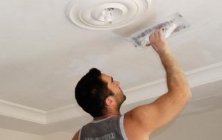 a man plastering the ceiling